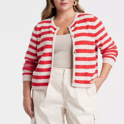 A woman wearing a white and red stripe cardigan jacket with beige top inside and white pants