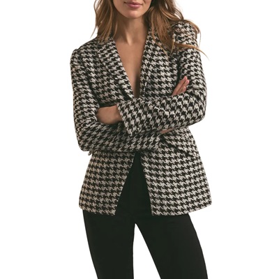 A woman wearing a houndstooth blazer and black pants