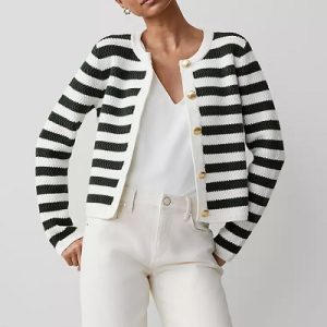 A woman wearing a black and white stripe jacket with white inner blouse and white jeans