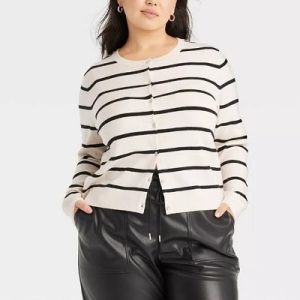 A woman wearing a black and white stripe knitted cardigan and black faux leather pants