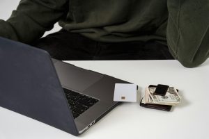 image of someone sitting at computer with credit card and wallet on table