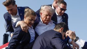 BUTLER, PENNSYLVANIA - JULY 13: Republican presidential candidate former President Donald Trump is rushed offstage by U.S. Secret Service agents after being grazed by a bullet during a rally on July 13, 2024 in Butler, Pennsylvania. Butler County district attorney Richard Goldinger said the shooter is dead after injuring former U.S. President Donald Trump, killing one audience member and injuring another in the shooting. (Photo by Anna Moneymaker/Getty Images)