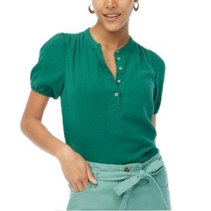 A woman wearing a green short sleeve top and light green pants