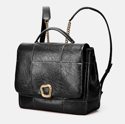 black backpack with crinkly leather effect, chain and leather straps, and an organic circular detail like a clasp