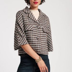 A woman wearing a short sleeve checkered wool jacket and denim pants