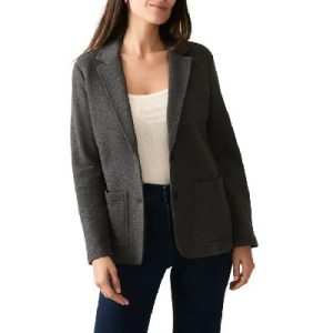 A woman wearing a dark gray blazer with white inner top and dark blue denim pants